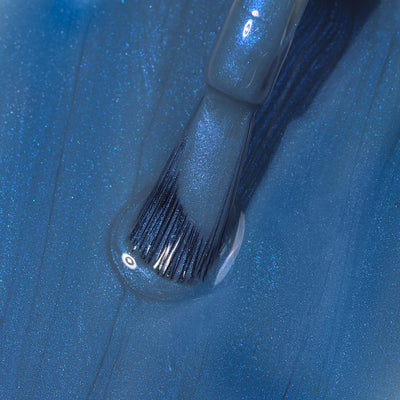 Close-up of a LONDONTOWN Blue Diamond nail polish brush applying sporty, shimmery blue nail polish with a glossy finish.