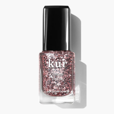 A bottle of LONDONTOWN Snowglobe Confetti Topper nail polish with a black cap, featuring a pink and silver glitter formula for a sparkling finish.
