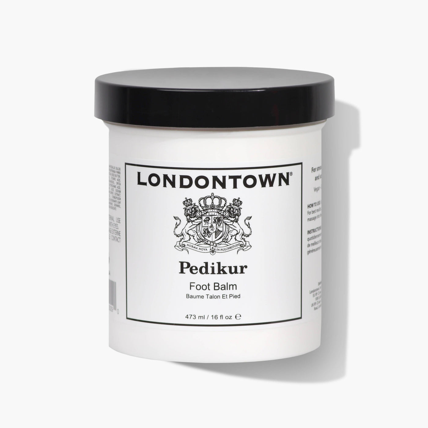 A white jar of LONDONTOWN's Foot Balm (Pro Size) with a black lid, adorned with a crest logo and the French text "Baume Talon Et Pied," provides 473ml (16oz) of nourishment for softer feet and smoother soles.