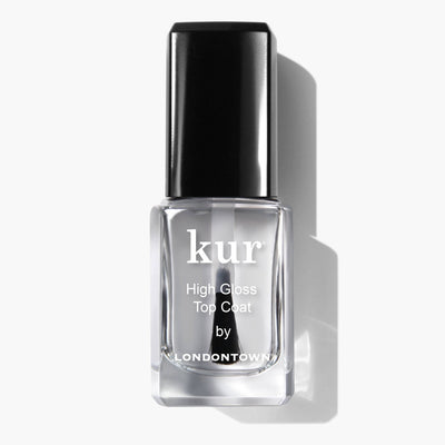 A bottle of High Gloss Top Coat (Professional) by LONDONTOWN, featuring a black cap and casting a shadow on a white background, provides an ultra-shiny finish that captivates the eye.
