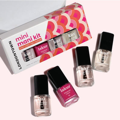 LONDONTOWN’s Mini Mani Kit - Mother's Day Set includes four polishes—two clear, one light pink, one dark pink—ideal for on-the-go manicures and shown both in and out of the packaging on a light background.