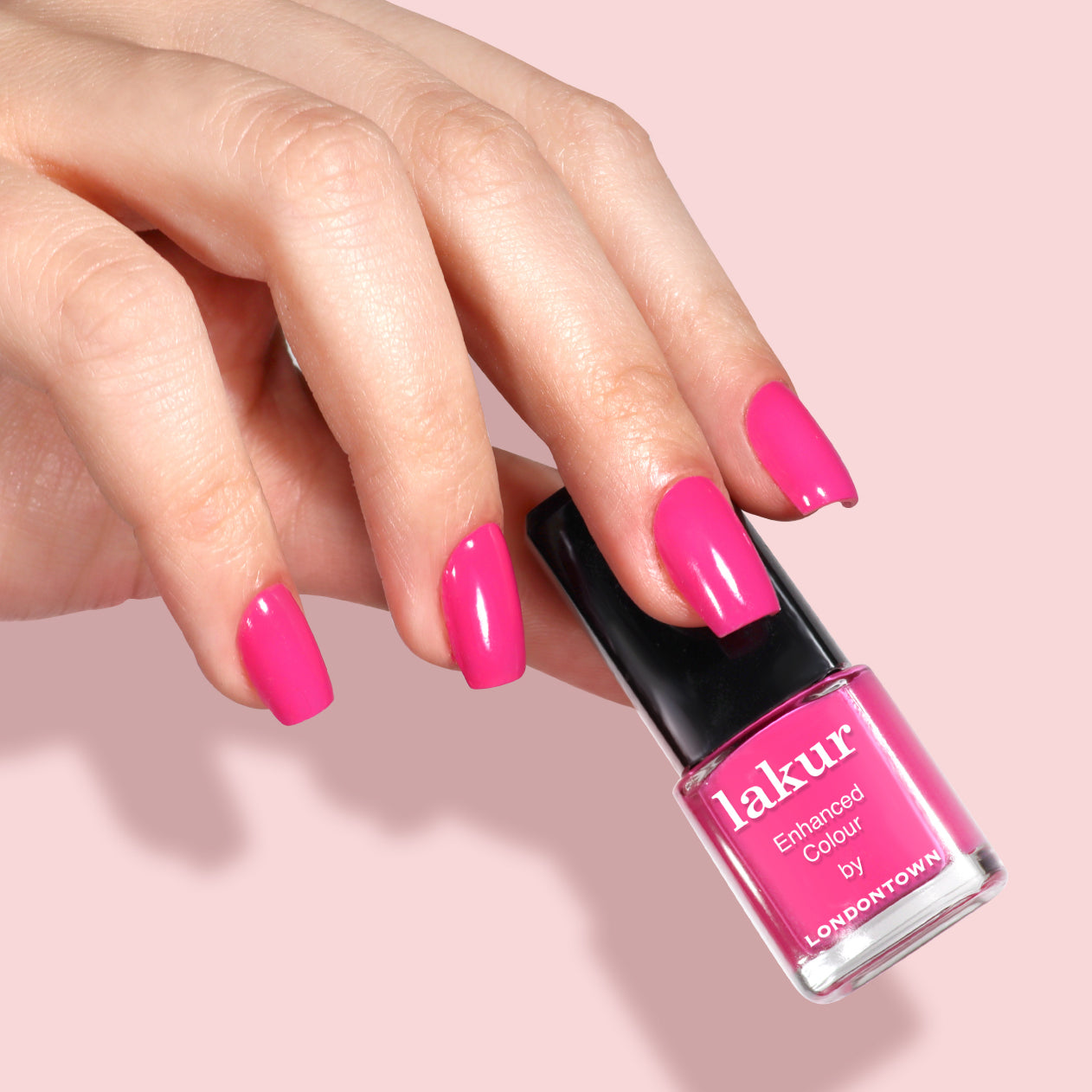 A hand with neatly manicured pink nails holds a LONDONTOWN Mini Mani Kit - Mother's Day Set against a light pink background—perfect for on-the-go manicures.