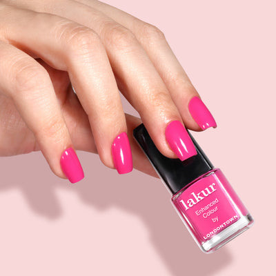 A hand with neatly manicured pink nails holds a LONDONTOWN Mini Mani Kit - Mother's Day Set against a light pink background—perfect for on-the-go manicures.