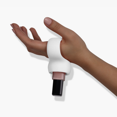 A hand wearing a LONDONTOWN Bottle Service Polish Holder with a bottle of nail polish secured in it, making easy manicures a breeze while the nails are being painted.