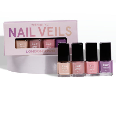 Four bottles of LONDONTOWN's Perfecting Nail Veil Mini Set are displayed in front of their packaging. The sheer colors include shades of nude, pink, and sweet purple.