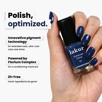 A graceful hand holds a dark blue "Under the Stars" nail polish by LONDONTOWN, featuring pigment technology. Highlighted by Florioum Complex and 21+ Free formula benefits, it perfectly complements your favorite vintage denim.