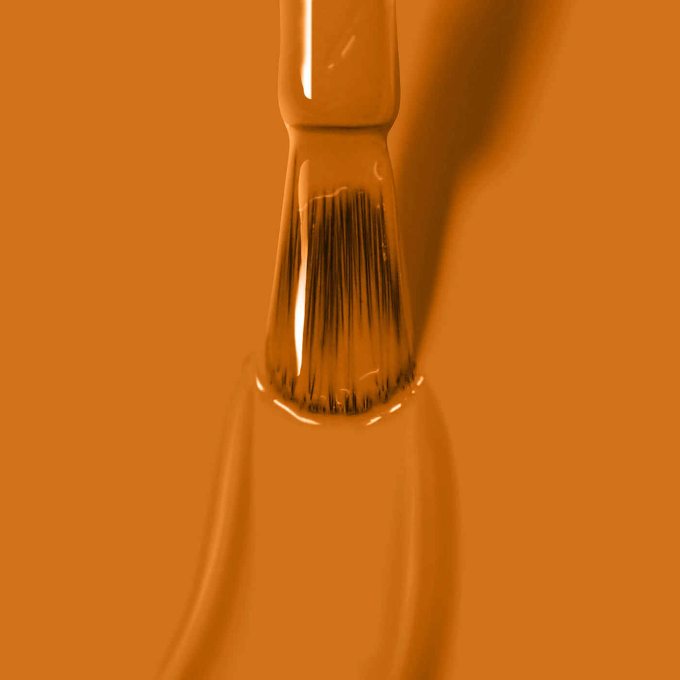 Close-up of a paintbrush dipped in Bee's Knees (Professional) paint by LONDONTOWN, with robust bristles coated and the surrounding surface covered in the same vibrant hue.