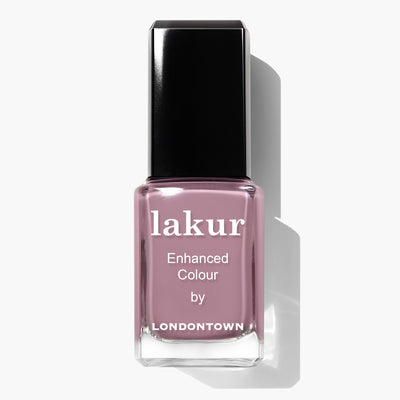 A bottle of LONDONTOWN Bell Flower lakur nail polish in a romantic dusty pink color with a black cap. The label reads "Enhanced Colour by.