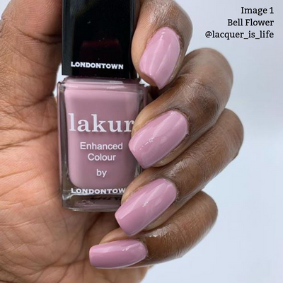A hand with romantic dusty pink nail polish holds a bottle of LONDONTOWN's lakur Enhanced Colour in the shade "Bell Flower." Text "Image 1 Bell Flower @lacquer_is_life" is in the top right corner, evoking a fairytale feeling reminiscent of the English countryside.