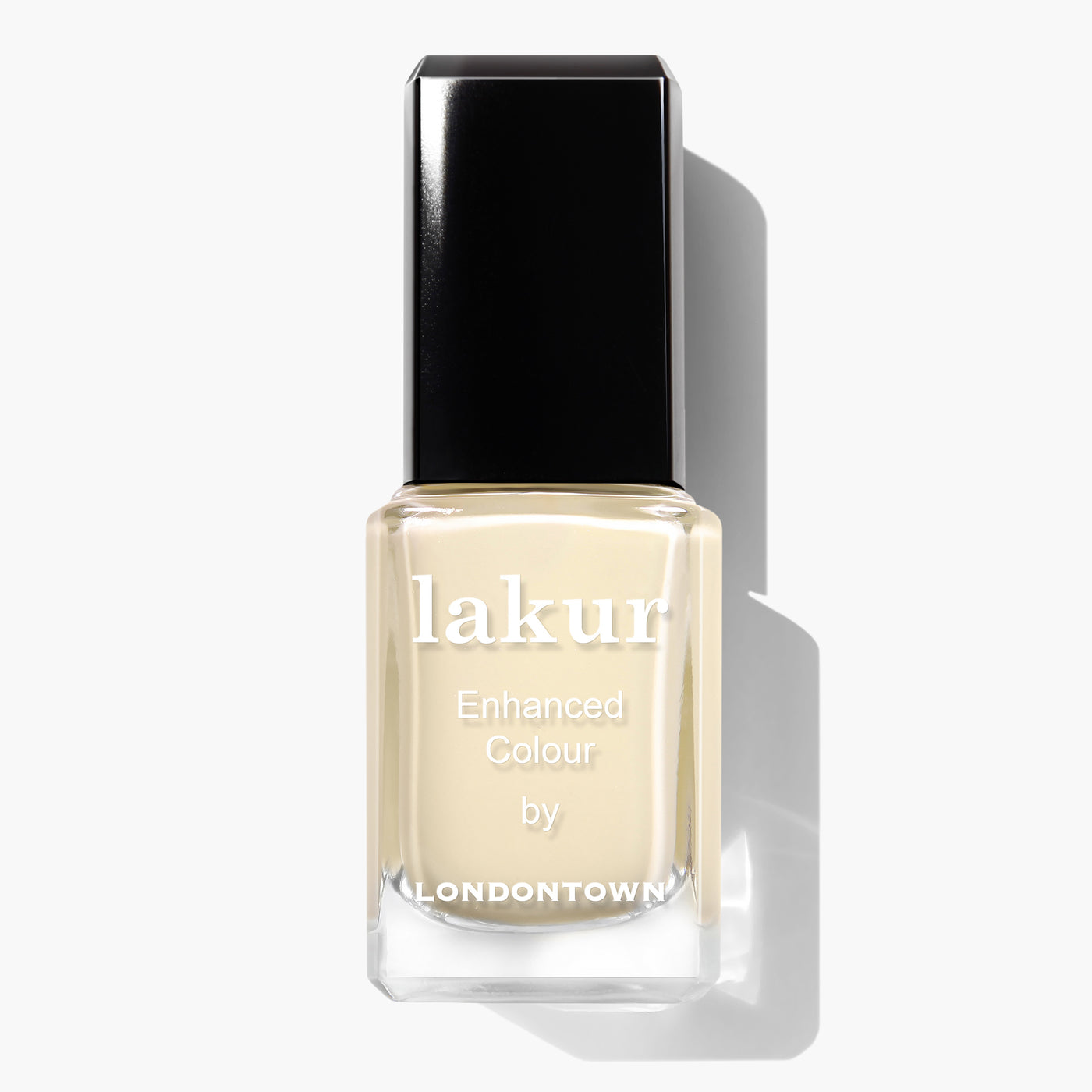 A bottle of Buttercup Lakur Enhanced Colour nail polish by LONDONTOWN, featuring a pastel yellow creme shade, with a black cap and clear bottle. This vegan, cruelty-free nail polish is also 16+ Free.