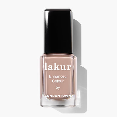Bottle of Lakur Enhanced Colour nail polish by LONDONTOWN in the Café Au Lait shade, a light beige, creamy taupe, on a white background. This vegan, cruelty-free formula is Florium Complex Infused for added nourishment.