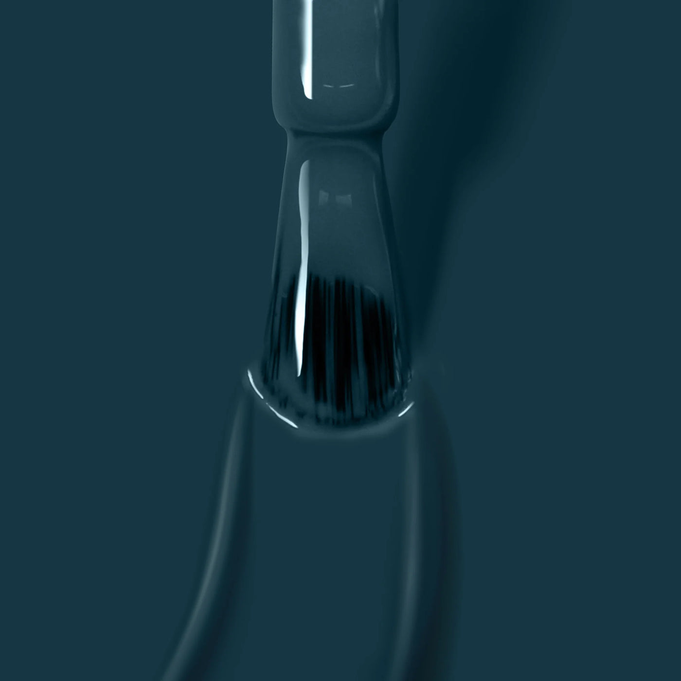 Close-up of a brush submerged in dark green paint, with bristles partly visible through a glossy layer of color, reminiscent of Chivvy Along (Professional) nail polish from LONDONTOWN.