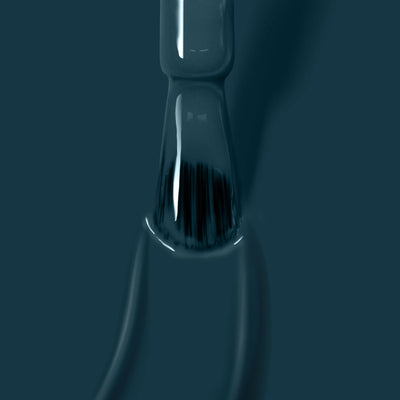Close-up of a brush submerged in dark green paint, with bristles partly visible through a glossy layer of color, reminiscent of Chivvy Along (Professional) nail polish from LONDONTOWN.