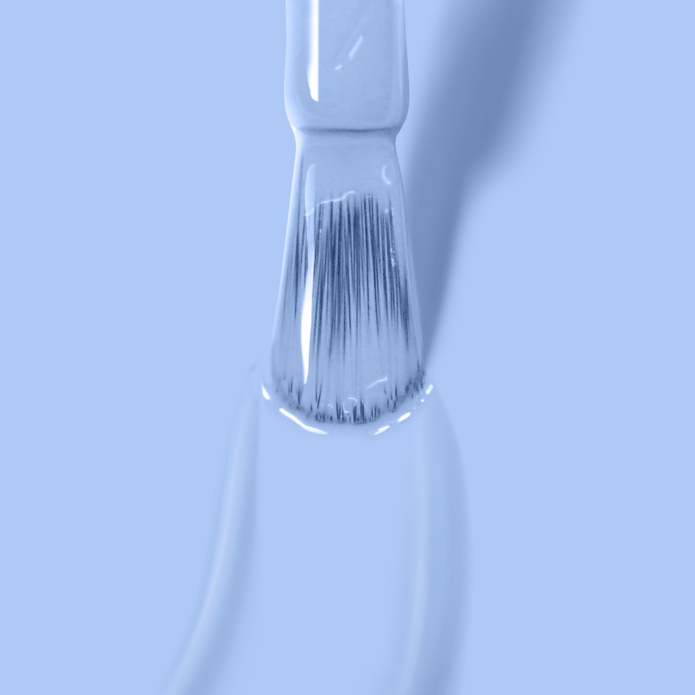 Close-up of a paintbrush bristles dipped in Chuffed to Bits by LONDONTOWN against a light blue background.