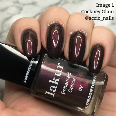 A hand with dark maroon vegan cruelty-free nail polish labeled "Cockney Glam (Professional) by LONDONTOWN," featuring the text "@accio_nails" on the image.