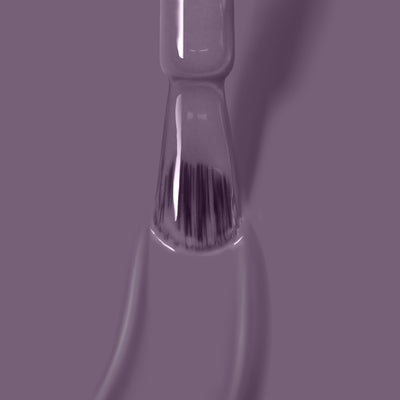 Close-up of LONDONTOWN's Cozy Cashmere nail polish brush with a bristle applicator, coated in a deep purple crème shade, against a matching purple background. Perfect for achieving salon-quality gel manicure results at home.