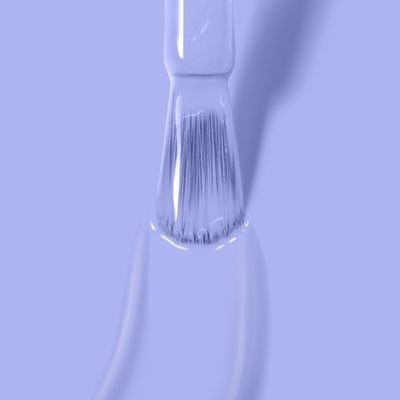 Close-up of a paintbrush applying LONDONTOWN's Dainty Daze, a light periwinkle blue creme paint.