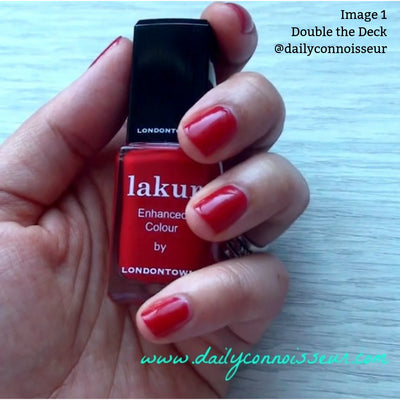 Close-up of a hand with red nail polish holding a matching red bottle labeled "Double the Deck (Professional) by LONDONTOWN." This vegan, formaldehyde-free nail polish in true red crème is featured. Text overlay indicates "Image 1 Double the Deck @dailyconnoisseur.