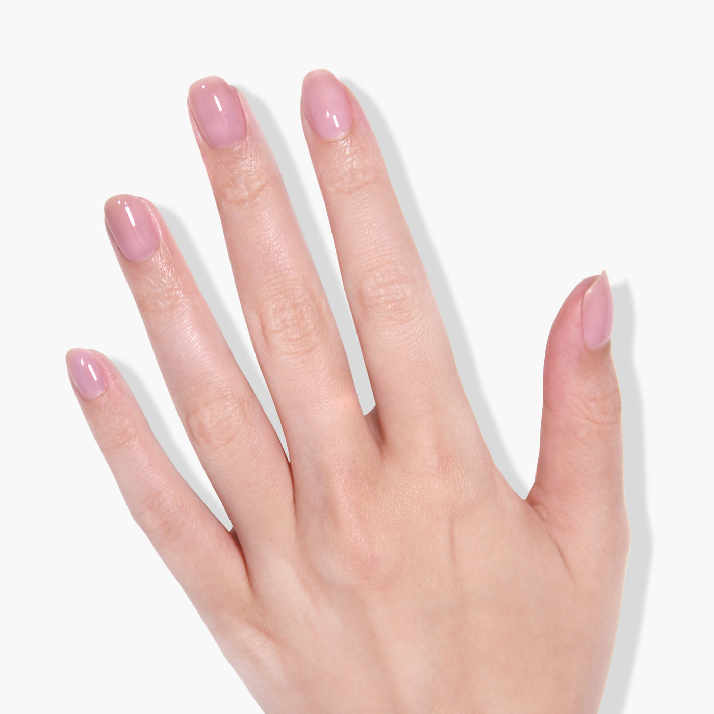A hand with neatly manicured nails painted in a light pink LONDONTOWN gel color, Fairy Charming, renowned for its super pigmented formula, is shown against a plain white background.