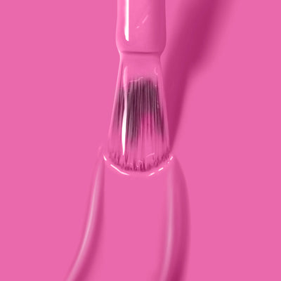 The LONDONTOWN Fruit Tella (Professional) nail polish brush, coated in hot pink polish, is showcased against a vibrant pink background.