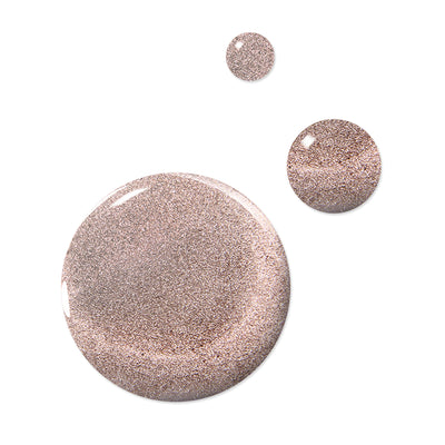 Three droplets of LONDONTOWN's Gilded, a rosy, glittery liquid, are shown against a plain white background, resembling the shimmer of cool champagne nail polish. The vegan, cruelty-free formula is PETA certified, with one larger droplet and two smaller ones sparkling in the light.