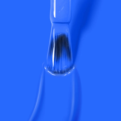 A paintbrush coated in Iconic (Professional) electric blue paint, reminiscent of LONDONTOWN's high-quality vegan cruelty-free nail polish, is shown against a matching blue background.