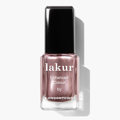 A bottle of LONDONTOWN's Kissed by Rose Gold Lakur Enhanced Colour, featuring a cruelty-free and vegan formula in a stunning metallic rose gold shade with a black cap, beautifully photographed against a white background.