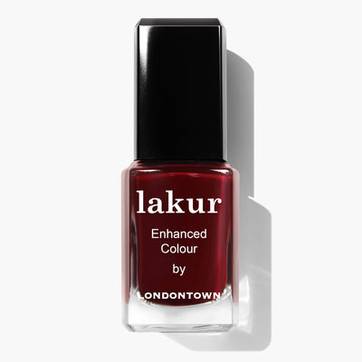A bottle of Lady Luck nail polish by LONDONTOWN, featuring a sleek black cap and filled with sultry burgundy crème, is displayed against a pristine white background.