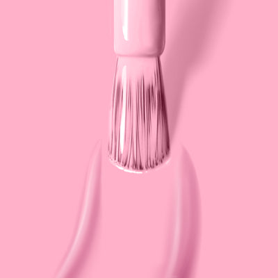 A brush applies LONDONTOWN's Lemonade Pop, a cruelty-free, light pink nail polish, on a matching muted pink background, with smooth strokes and even coverage.