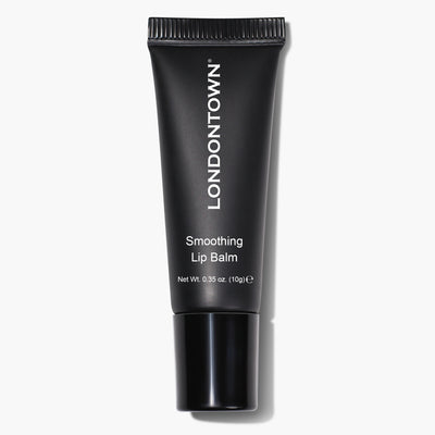 A black tube of Smoothing Lip Balm from LONDONTOWN, featuring white text indicating its name and net weight of 10 grams (0.35 oz), provides an ultra-rich, conditioning lip treatment.