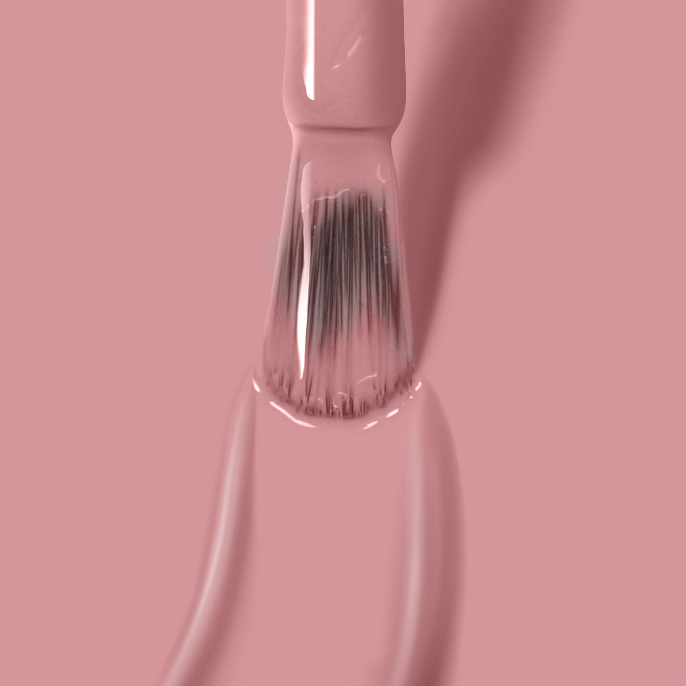 A paintbrush being dipped in LONDONTOWN's Mauve Over paint on a light pink background.