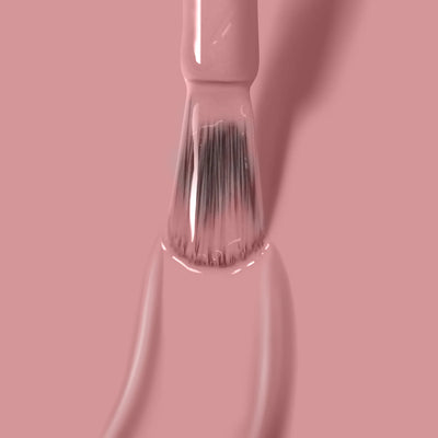 Close-up of a nail polish brush coated with LONDONTOWN's Mauve Over (Professional) vegan, cruelty-free, PETA certified dusty rose nail polish, isolated against a solid pink background. The brush is in the process of applying the polish.