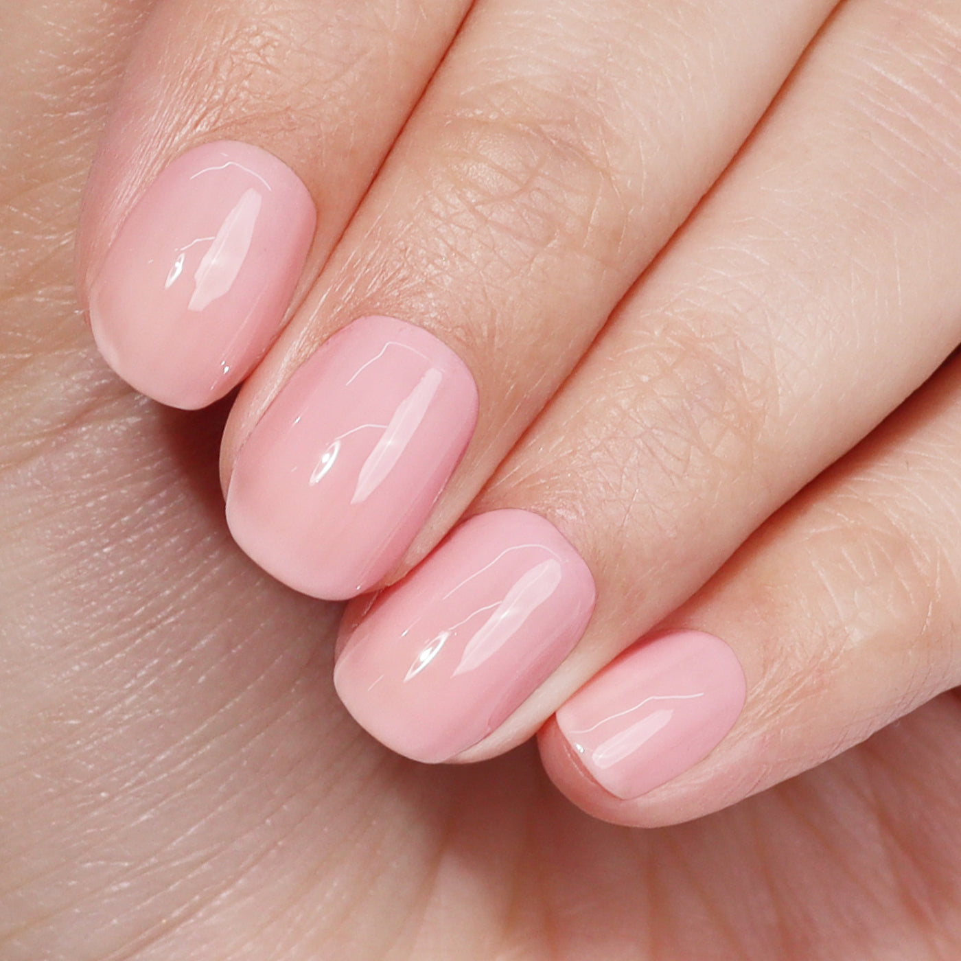 Close-up of a hand with short, well-manicured nails painted in the glossy pink shade of LONDONTOWN's Perfecting Nail Veil #7, showcasing the power-packed color and attention to detail.