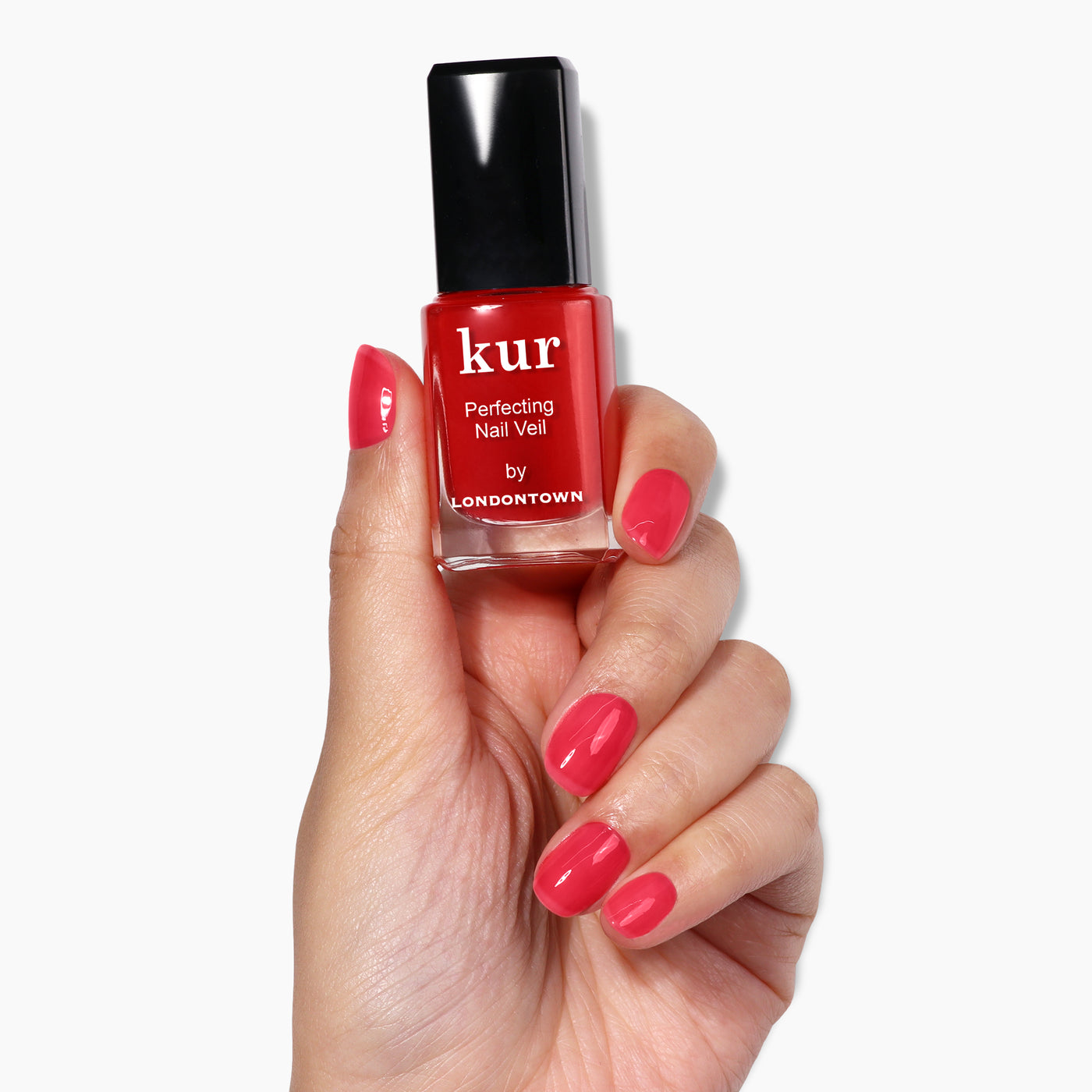 A hand with neatly painted nails in a vibrant red shade holds a bottle of LONDONTOWN's "Perfecting Nail Veil #8" nail polish, showcasing its care and powerful color.