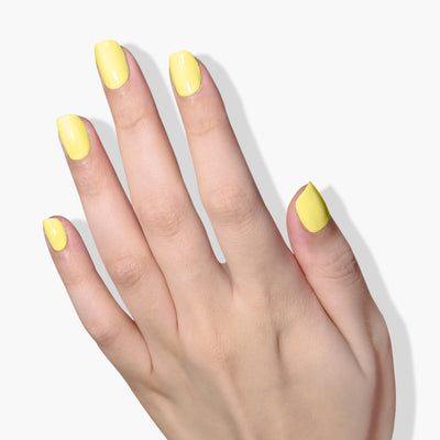 A hand with neatly trimmed nails painted in LONDONTOWN's vibrant, cruelty-free Notting the Fancy lemon meringue yellow nail polish against a white background.