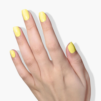 A hand with neatly manicured nails painted in the vibrant Notting the Fancy (Professional) lemon meringue yellow nail polish by LONDONTOWN, set against a plain white background.