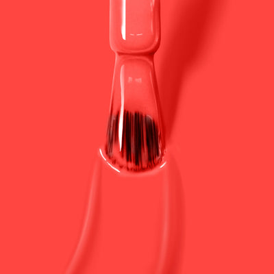 Close-up of a brush applying bright red nail polish from LONDONTOWN's collection, showcasing their ultra-bright blood orange crème "Piccadilly Square (Professional)" on a smooth surface.