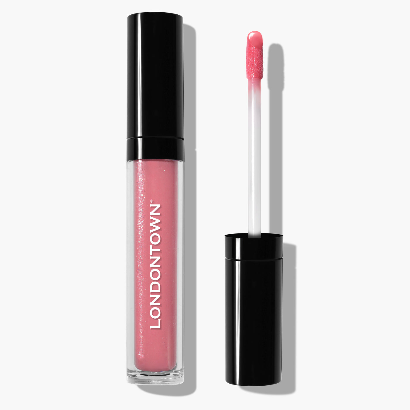 A tube of Plush Shine Lip Gloss - Pixie by LONDONTOWN, in a milky pink shade, with the applicator wand resting beside it.