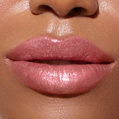 Close-up of a person's lips with LONDONTOWN's Plush Shine Lip Gloss in Pixie applied, showcasing a smooth and moisturized appearance with a milky pink, glossy finish.