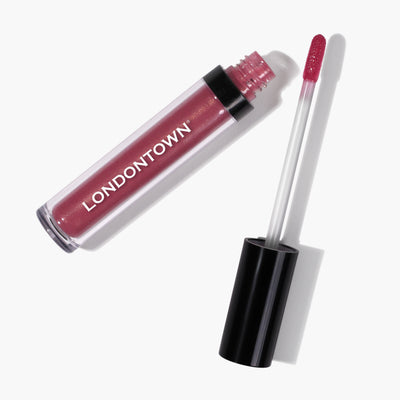 A tube of LONDONTOWN's Plush Shine Lip Gloss in the shade 'Posh' with its applicator wand partially removed, revealing the flushed pink gloss.