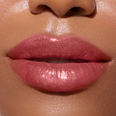 Close-up view of flushed pink, glossy lips with a subtle shimmer brought to life by Plush Shine Lip Gloss - Posh from LONDONTOWN. The focus is on the lips, highlighting their smooth texture and natural shine.