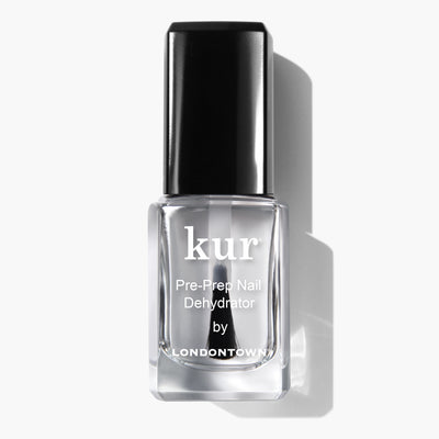 A clear glass bottle labeled "Pre-Prep Nail Dehydrator" by LONDONTOWN, featuring a black cap and designed for optimal professional polish preparation, displayed against a white background.