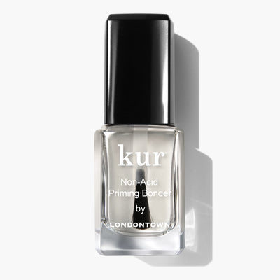 A bottle of "Non-Acid Priming Bonder by LONDONTOWN" featuring a black cap, photographed against a white background—a pro secret for long-lasting manis.