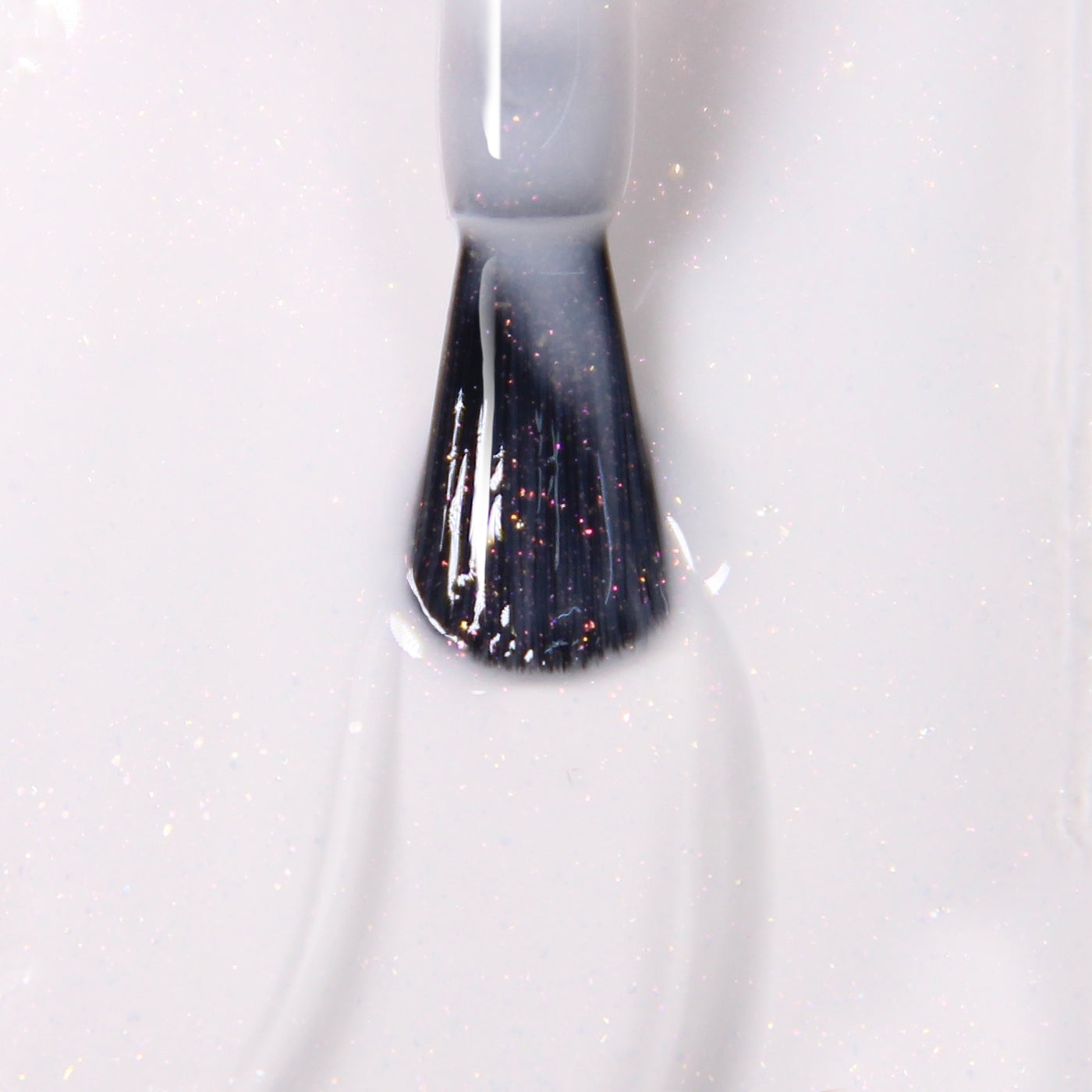 Close-up of a brush applying LONDONTOWN's Princess Awaits, a light, shimmery, vegan cruelty-free nail polish, to a surface.