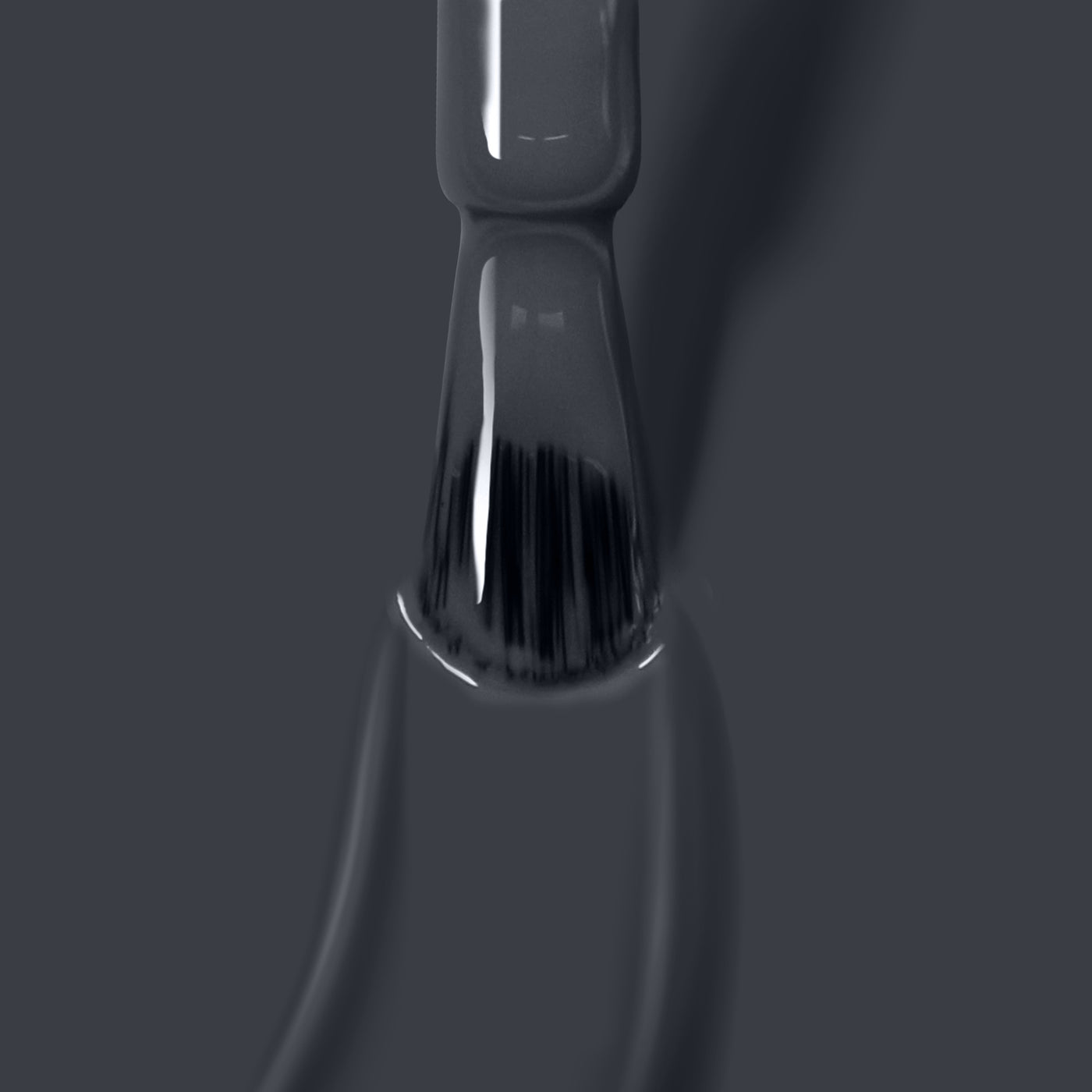 Close-up of a LONDONTOWN Put the Kettle On nail polish brush being pulled out of the bottle, showcasing vegan cruelty-free nail polish on the bristles against a grey background.
