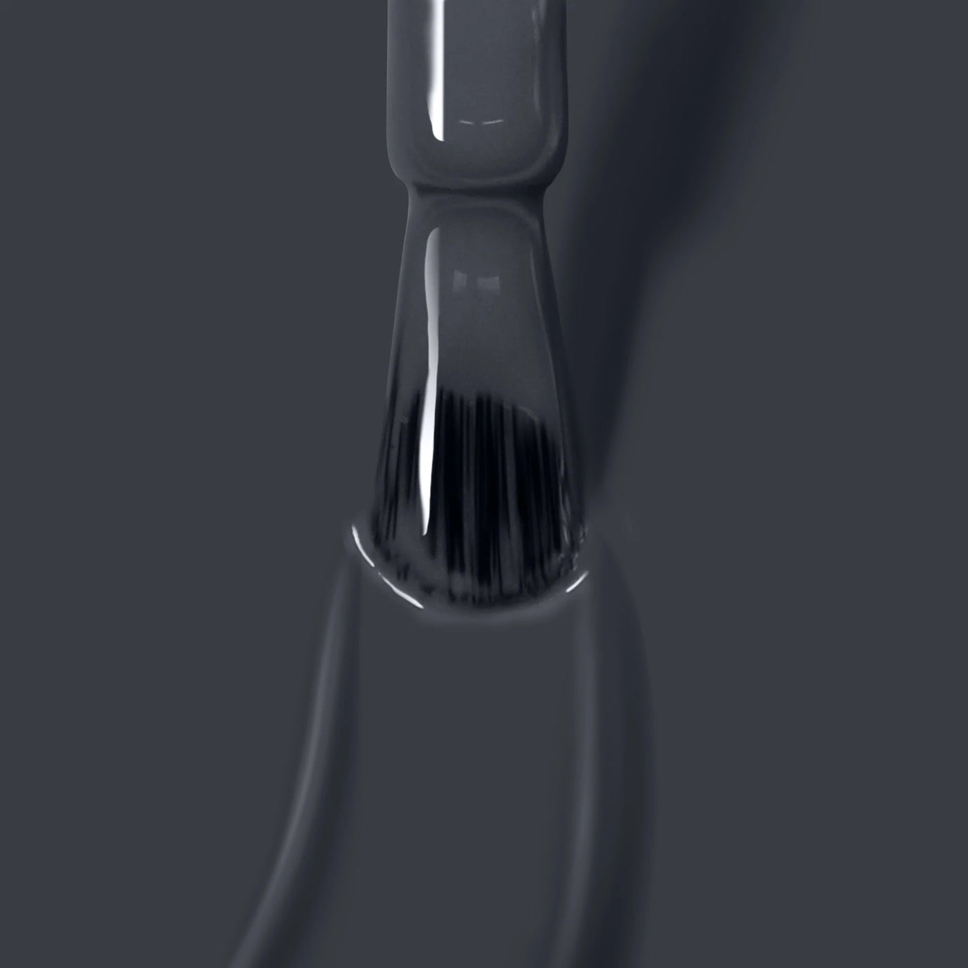 Close-up of a brush applying the glossy, dark *Put the Kettle On (Professional)* vegan nail polish by *LONDONTOWN* on a surface, with visible bristles and wet strokes.