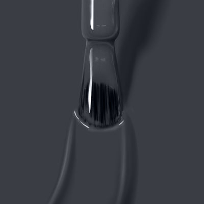 Close-up of a LONDONTOWN Put the Kettle On nail polish brush being pulled out of the bottle, showcasing vegan cruelty-free nail polish on the bristles against a grey background.