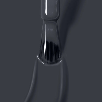 Close-up of a brush applying the glossy, dark *Put the Kettle On (Professional)* vegan nail polish by *LONDONTOWN* on a surface, with visible bristles and wet strokes.