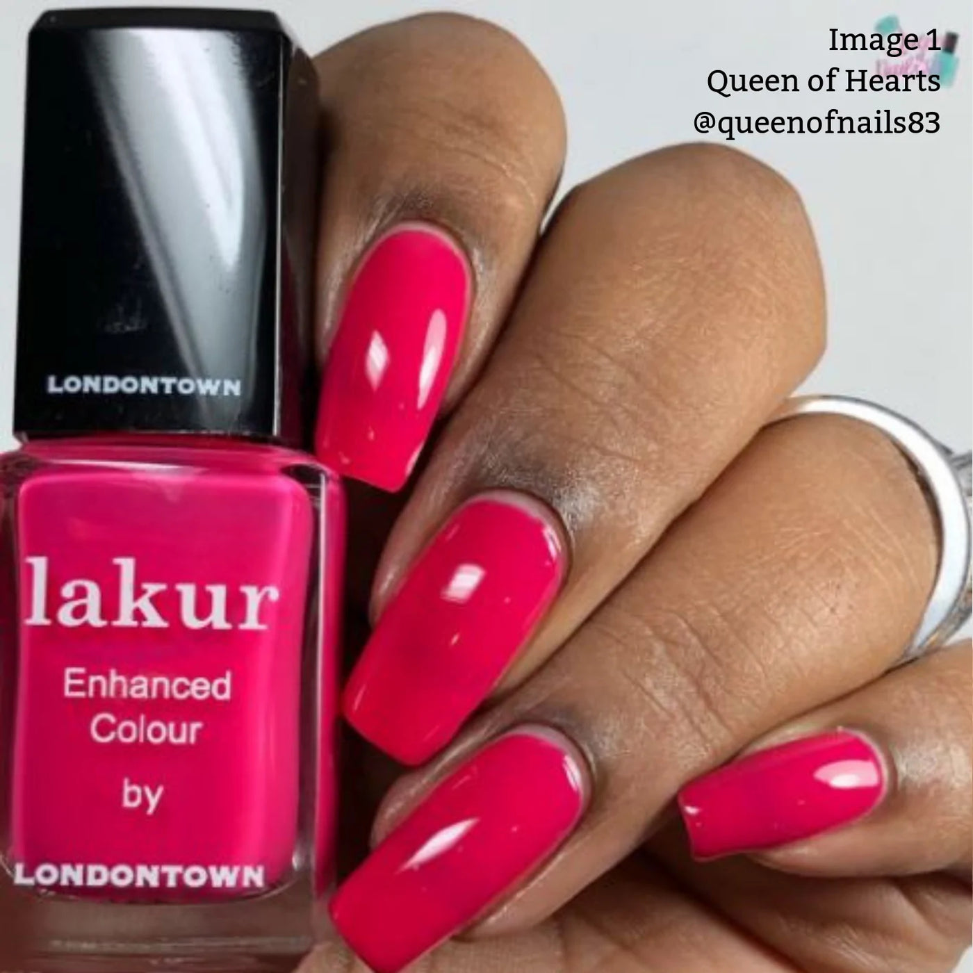 A hand with manicured nails painted in the glossy deep fuchsia pink crème of LONDONTOWN's Queen of Hearts (Professional) nail polish. The bottle of matching Queen of Hearts, known for its cruelty-free formula, is held next to the nails—perfect for a party manicure.