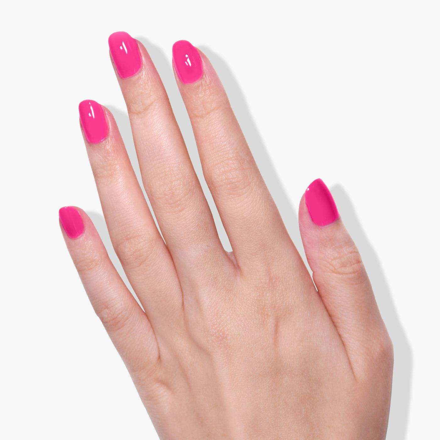 A hand with nails manicured in the deep fuchsia pink crème shade "Queen of Hearts" by LONDONTOWN is displayed against a white background.